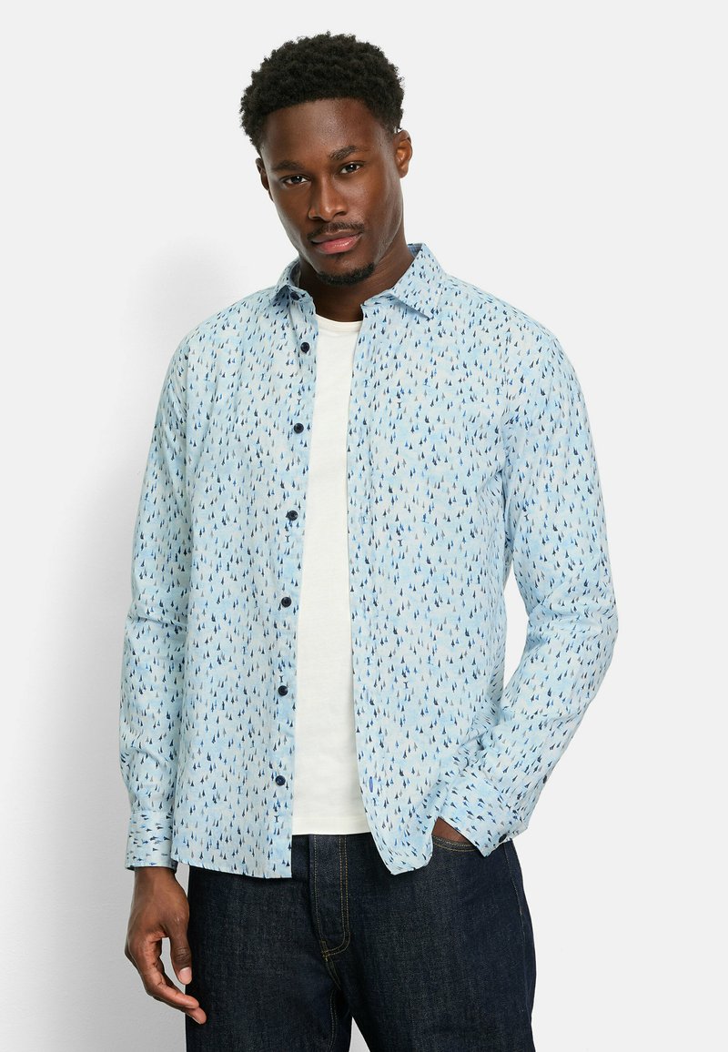 Helles blaues Hemd mit Knöpfen, verziert mit einem Muster aus kleinen, dunkelblauen Bäumen. Hergestellt aus einem weichen Stoff, mit langen Ärmeln und einem lässigen Schnitt.