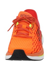 Helles orange Sport Schuh mit Mesh-Obermaterial, strukturiertem Muster, flachen Schnürsenkeln und schwarzer Sohle. Verfügt über das Branding 'Air Cooled' auf der Zunge.