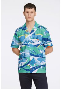 Camicetta a maniche corte con bottoni in verde e blu vivaci, decorata con motivi di paesaggi, con colline, alberi e piccole case sparse.