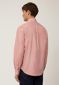 Camisa de rayas rojas y blancas con mangas largas, cuello estándar, puños abotonados y dobladillo curvado, hecha de tela ligera.