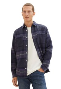 Męska koszula w ciemnoniebieską kratę, wykonana z miękkiego materiału, z jasnoszarymi paskami, dwoma kieszeniami na piersiach, z guzikami z przodu oraz luźnym krojem.