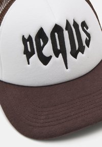 White and brown cap with a curved brim; features black embroidered text "pequs" on the front; mesh back panel texture.