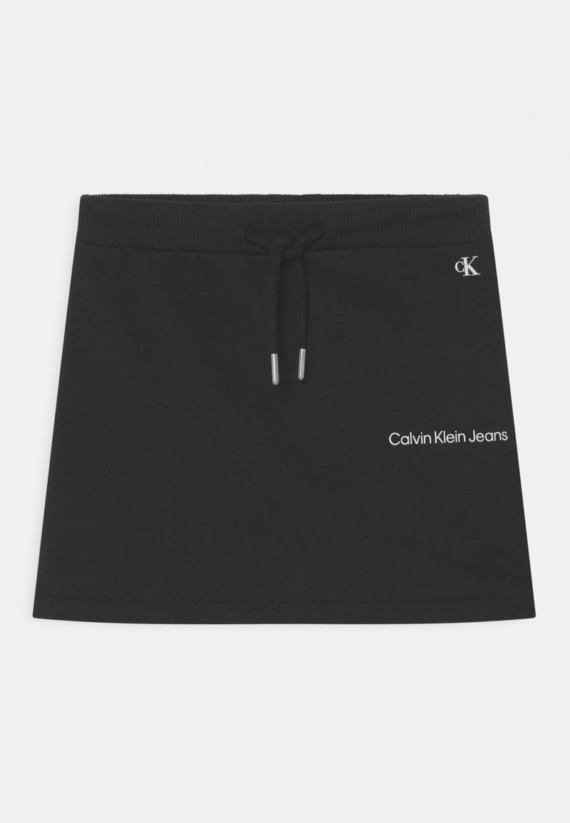 Musta puuvillainen mini-hame, jossa on nauhavyötärö. Takataskussa pieni hopea-logo ja teksti "Calvin Klein Jeans" valkoisella. Sileä pinta.