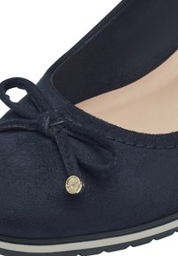 Mornarničko plava suede balerinka s malim detaljem u obliku mašne i zlatnim akcentom. Ima meku unutrašnju podstavu i teksturiran spoljašnji đon.