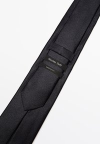 Cravate noire texturée avec un design épuré, dotée d'une pointe arrondie et de marques de fabrique cousues dans le tissu, indiquant "Massimo Dutti" et "Fabriqué en Italie."