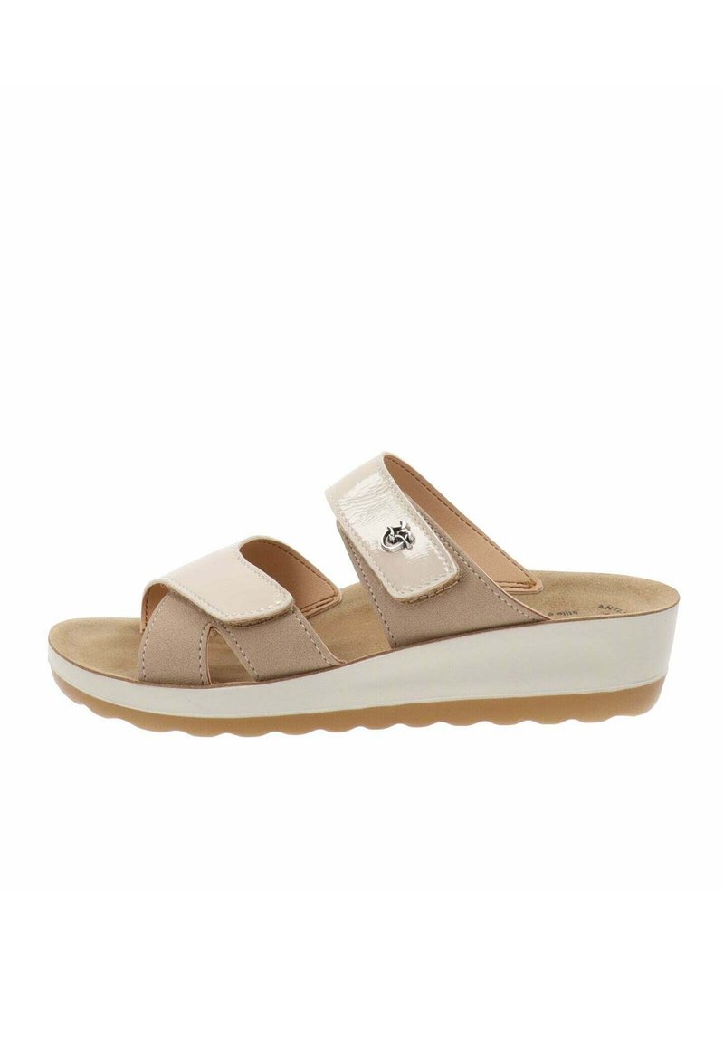 Sandali in suede beige con cinturini lucidi e chiusura in Velcro regolabile, soletta imbottita e una suola piatta bianca con fondo testurizzato.