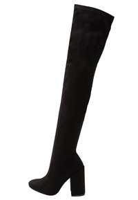 Botas negras de tirantes por encima de la rodilla hechas de un tejido suave, con tacón cuadrado, textura lisa y silueta ajustada.