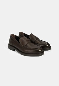 Braune Lederloafers mit strukturiertem Finish, zulaufender Zehenpartie und einem gesteppten Band über dem Spann. Gummisohle. Klassisches Design.