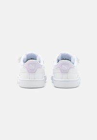 Hvite sneakers med en glatt læroverflate. Har lilla detaljer på hæltappen og en polstret innside. Lavt design.