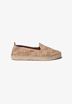 Zapato de esparto tejido tipo slip-on en tono natural tostado con un patrón texturizado y una suela de cuerda de yute, que presenta un perfil bajo y punta redondeada.