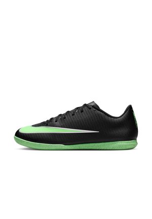 Nízky čierny halový futbalový kopačka so zelenou podrážkou a zeleným logom Nike na boku, viazaný na šnúrky, zobrazený z ľavej bočnej strany.