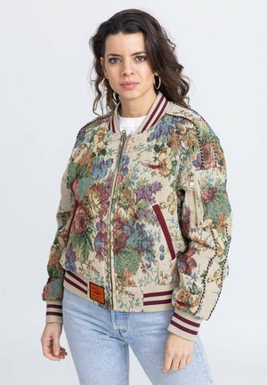 Kwiatowa kurtka bomberka z beżowego materiału, ozdobiona wielokolorowym wyszyciem, bordowymi ściągaczami przy rękawach oraz kieszenią zapinaną na zamek błyskawiczny na rękawie.