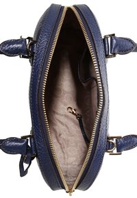 Niebieska skórzana torebka z złotym zamkiem, otwarta, aby pokazać beżową podszewkę z wzorem oraz mały zapięty pasek w środku.