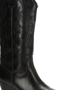 Bota de vaquero negra de cuero alta con intrincados patrones florales bordados en la caña y puntera puntiaguda.
