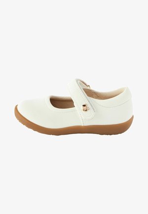 White leather Mary Jane shoe with a rounded toe, adjustable strap, and tan rubber sole. Features a smooth texture and a gold accent.