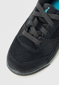 Czarne zamszowe sneakersy z teksturowanymi panelami z siateczki, grubymi czarnymi sznurowadłami oraz widocznym jasnoniebieskim logo na wyściełanym języku.