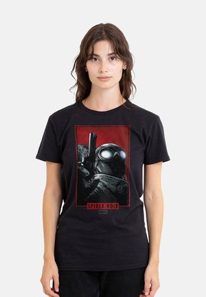 Young woman wearing a black Spider-Noir Marvel t-shirt featuring a stylized character with goggles and a gun on a red background.