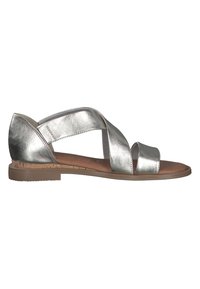 Sandali metallici argento con design a cinghia incrociata, suola piatta e soletta imbottita. Accento in sughero sulla suola per texture e comfort.