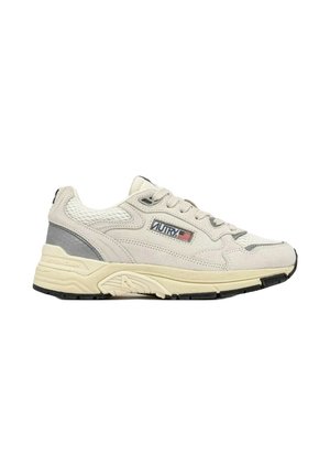 Sneakers in scamosciato beige con dettagli in rete, dotati di un collo imbottito, chiusura con lacci e una spessa suola in gomma nera. Accentuati da un logo.