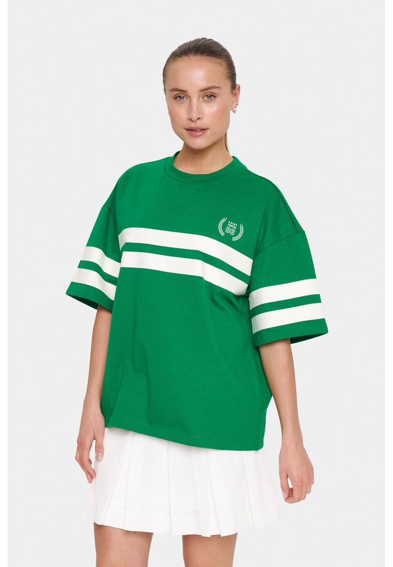 T-shirt verde oversize in cotone con strisce orizzontali bianche sulle maniche, caratterizzato da un piccolo logo sul petto e una vestibilità rilassata.