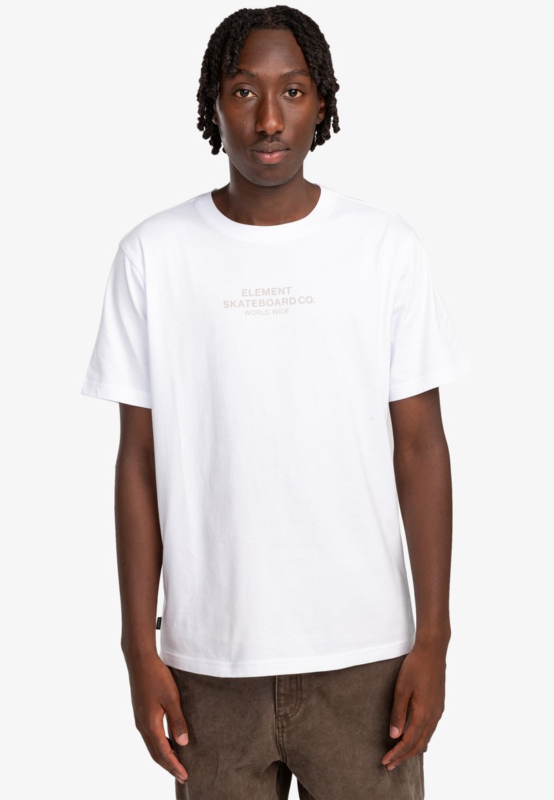 Camiseta blanca de algodón con mangas cortas, que presenta un logo impreso en beige claro "ELEMENT SKATEBOARD CO. WORLD WIDE" en la parte delantera.