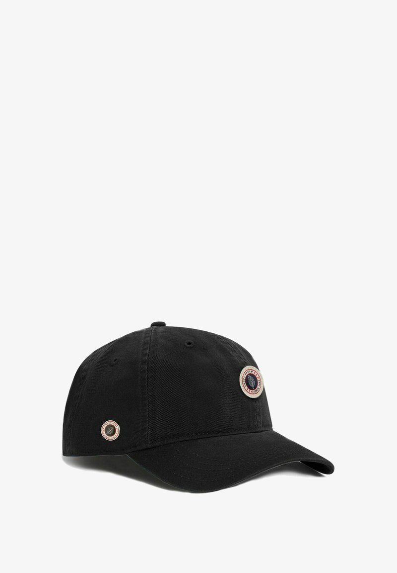 Casquette de baseball en coton noir avec une visière courbée, présentant deux patchs métalliques sur le devant. Tissu texturé avec des détails de couture.