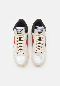 Sneaker alte con una tomaia in pelle bianca, dettagli in suede rosso e nero, punta perforata e lacci crema.