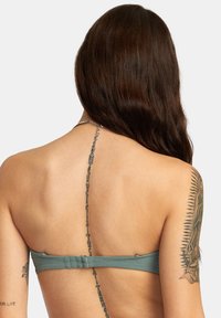 Top bikini bandeau verde acqua con materiale texturizzato, dettagli in catena metallica regolabile sul retro e chiusura a gancio.