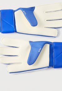 Γάντια τερματοφύλακα σε μπλε χρώμα με λευκές παλάμες από λάτεξ, υφή στην πίσω πλευρά και λουράκι με βέλκρο. Διακριτικά γράμματα "MATCH" στον αντίχειρα.