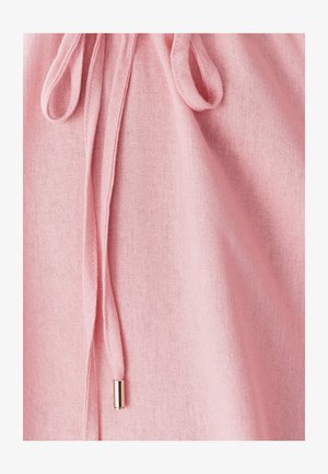 Tissu rose clair avec une surface texturée, présentant un cordon avec un embout en métal. Le tissu tombe doucement.