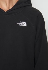 Felpa con cappuccio nera realizzata in tessuto morbido. Presenta il logo ricamato bianco di The North Face sulla parte superiore sinistra del petto.