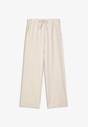 Beżowe szerokie spodnie z elastycznym pasem, ściągaczem i bocznymi kieszeniami. Gładka tkanina bez widocznych wzorów ani akcentów.