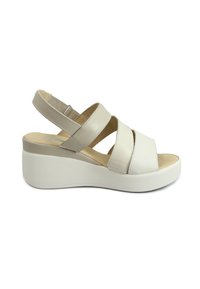 Sandal beige con fasce larghe in pelle, punta aperta e cinturino posteriore regolabile. Caratterizzata da una suola a zeppa bianca per un'altezza extra.