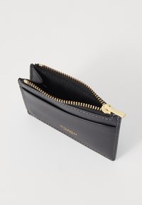 Black leather wallet with a zippered compartment, gold hardware, and a smooth texture. Features a card slot and the brand logo embossed on the front.