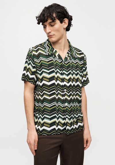 Κοντομάνικο πουκάμισο με ζιγκ-ζαγκ μοτίβο σε πράσινο, μαύρο και λευκό, με γιακά κάμπινγκ και μπροστινό κούμπωμα με κουμπιά. Λείο ύφασμα.