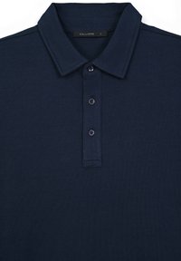 Polo shirt blu navy realizzato in tessuto morbido, con colletto classico, placket a tre bottoni e dettagli di cucitura discreti.