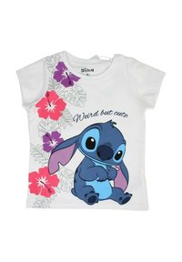 T-shirt en coton blanc présentant un personnage de dessin animé bleu avec de grandes oreilles, des motifs floraux en rose et violet, et le texte « Bizarre mais mignon. »