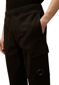 Schwarze Cargo-Hosen aus weichem Stoff, mit Seitentasche mit Druckknopfverschluss, elastischem Bund und dezenten Taschen-Details.