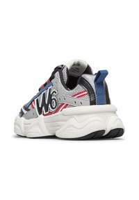 Sneaker bianco e grigio con tomaia in rete, accenti rossi e blu, suola spessa e logo oversized. Il tallone presenta un linguetta blu.