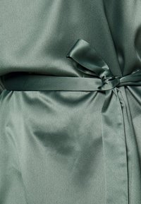 Abito avvolgente in satin di un morbido colore verde, caratterizzato da una texture liscia, cintura in vita e un design elegante.