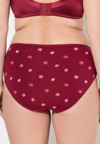 Bordeaux hooggetailleerde slips met een bloemmotief in roze en lichtere tinten. Zachte stof met elastieke tailleband en een gladde textuur.
