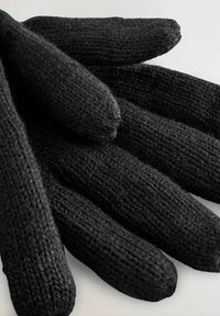 Schwarze gestrickte Handschuhe mit weicher Textur, die verlängerte Finger und einen engen Sitz haben. Der Stoff ist grob und leicht fusselig.