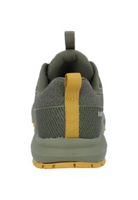 Groene sportieve schoenen met een gestructureerde mesh bovenkant, gele hiel lus en een rubberen buitenzool met gripnoppen voor stabiliteit.