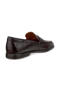 Mocassins en cuir brun foncé avec une surface lisse, un bout arrondi et un petit talon. Caractérisés par un design cousu et un style facile à enfiler.