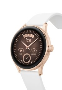Orologio smarttondo con cassa in metallo rosa oro, quadrante marrone, cinturino in silicone bianco e ghiera nera. Le caratteristiche includono contatori di salute e passi.