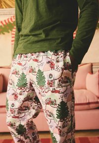 Bomullspyjamabyxor med ett festligt, färgglatt mönster med julscener, träd och dekorationer. Elasticerad midja och sidofickor.