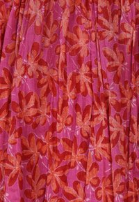 Floral print fabric featuring large, bold orange flowers on a pink background. The texture appears smooth with subtle pleats.