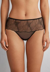 Black sheer lingerie with a wavy pattern, featuring a textured mesh panel at the top and matching solid lower portion.