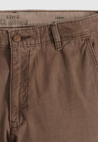 Bruine Levi's Max Chino broek met een losse pasvorm, voorzien van een knoopsluiting, riemlussen en gebreide stof met een subtiele glans.