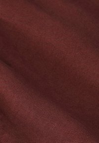 Tissu texturé d'une riche couleur bordeaux, présentant de subtiles rayures horizontales, créant de la profondeur et de l'intérêt visuel. Aspect lisse et léger.